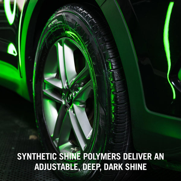 Glossy, dark tire treated with Turtle Wax Hybrid Solutions graphene tire shine. Black car, and silver rim.